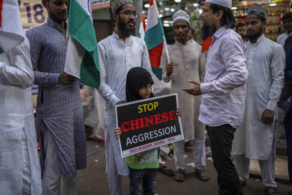 An Indian girl holds a placard during a protest against China in Mumbai, India, Tuesday, Dec. 13, 2022. Soldiers from India and China clashed last week along their disputed border, India's defense minister said Tuesday, in the latest violence along the contested frontier since June 2020, when troops from both countries engaged in a deadly brawl. (AP Photo/Rafiq Maqbool)