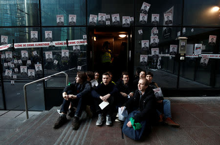 Environmental activists block the entrance of the French bank Societe Generale headquarters during a "civil disobedience action" to urge world leaders to act against climate change, in La Defense near Paris, France, April 19, 2019. REUTERS/Benoit Tessier