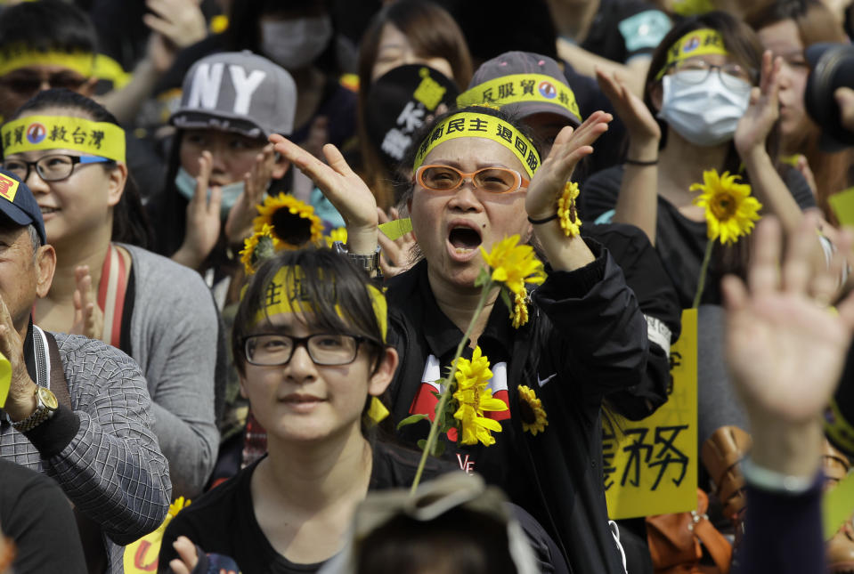 Protesters shout slogans denouncing the controversial China Taiwan trade pact during a massive protest in front of the Presidential Building in Taipei, Taiwan, Sunday, March 30, 2014. Over a hundred thousand protesters gathered in the demonstration against the island's rapidly developing ties with the communist mainland. (AP Photo/Wally Santana)