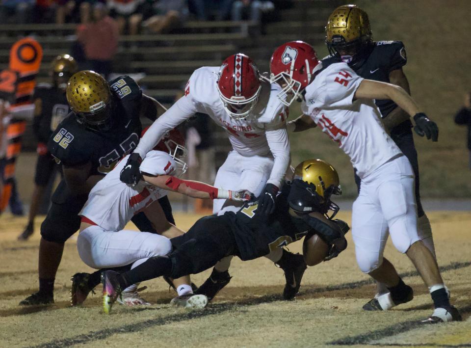 Shelby's Tristan Tate powers through an East Surry tackler and into the end zone during a second quarter outburst by the Golden Lions.