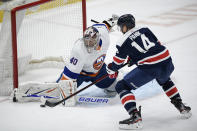 New York Islanders goaltender Semyon Varlamov (40) stops the puck in front of Washington Capitals right wing Richard Panik (14) during the first period of an NHL hockey game Tuesday, Jan. 26, 2021, in Washington. (AP Photo/Nick Wass)