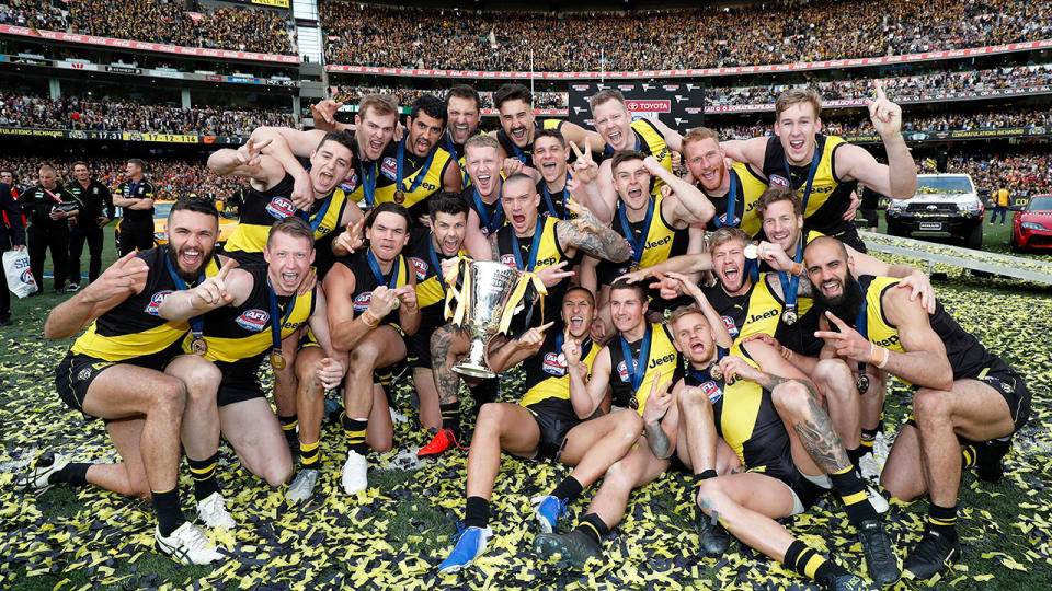 Richmond's squad are pictured here with the 2019 AFL premiership trophy.