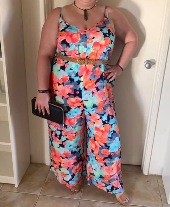 A photo of a woman wearing a floral Kmart jumpsuit.
