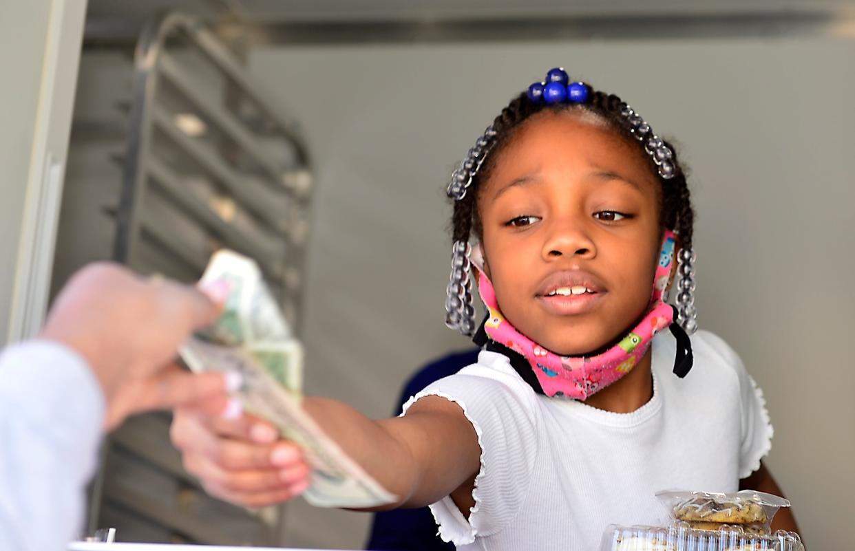 Sweets on the Run is a dessert food truck in Spartanburg owned by Ranada Price.  This is her business on March 4, 2022 at 297 West Henry Street in Spartanburg. Ka'Mori Woodruff, 8, works with her mother waiting on guests. 