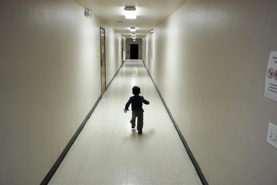 FILE - In this Dec. 11, 2018 file photo, an asylum-seeking boy from Central America runs down a hallway after arriving from an immigration detention center to a shelter in San Diego. The Trump administration will make a case in court to end a longstanding settlement governing detention conditions for immigrant children, including how long they can be held by the government. A hearing is scheduled before a federal judge Friday, Sept. 27, 2019, in Los Angeles over the so-called Flores settlement. (AP Photo/Gregory Bull, File)