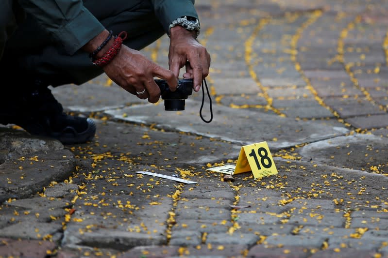 An Indonesian forensic policeman takes pictures of evidence of a blast at National Monument (Monas) complex in Jakarta