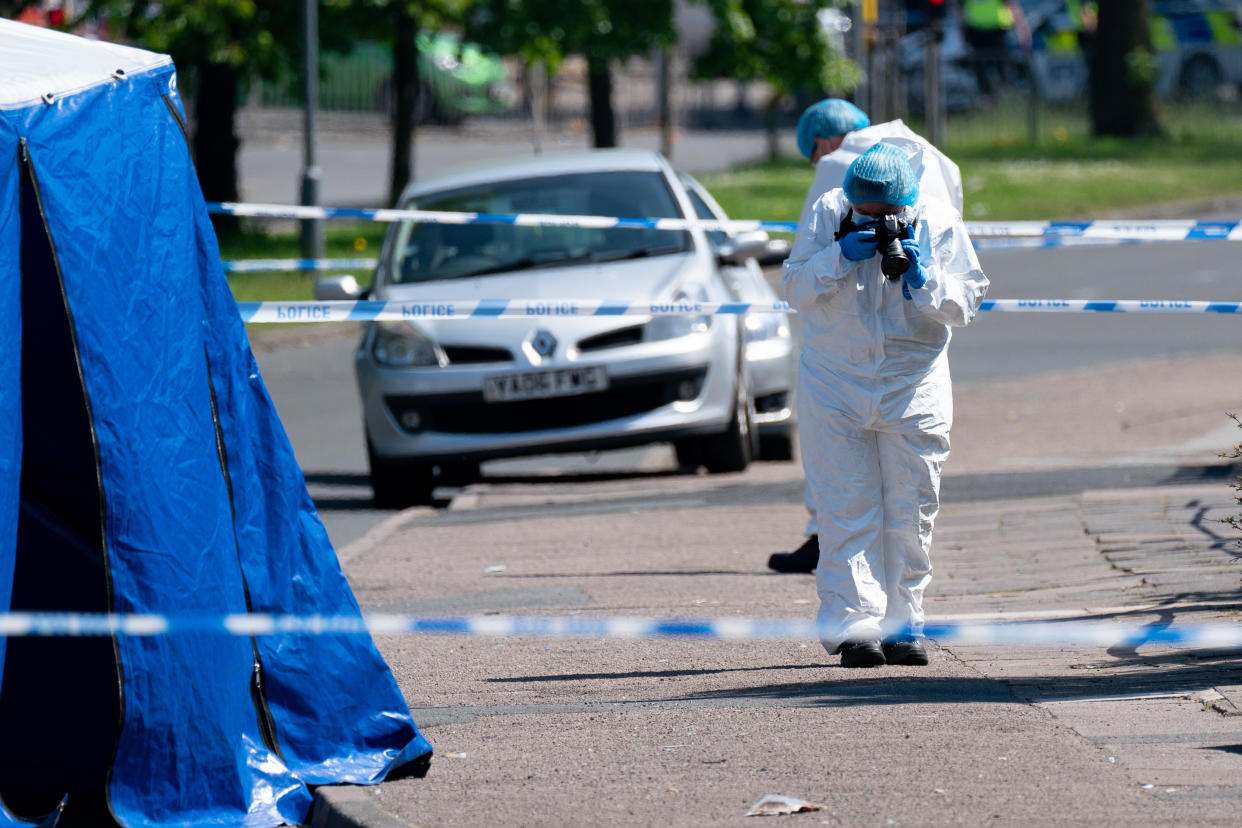 A forensics officer takes photographs at the scene on College Road, Kingstanding, north of Birmingham, where a 14-year-old boy died after being stabbed on Monday evening. Police have launched a murder investigation and are hunting up to seven people in connection with the attack. Picture date: Tuesday June 1, 2021.