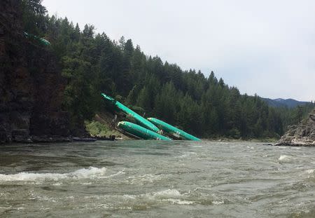 Three Boeing 737 fuselages lie on an embankment on the Clark Fork River after a BNSF Railway Co train derailed Thursday near Rivulet, Montana in this picture taken July 4, 2014. REUTERS/Andrew Spayth