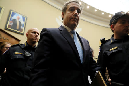 Michael Cohen, the former personal attorney of U.S. President Donald Trump, is flanked by U.S. Capitol police officers as he leaves for a break while testifying before a House Committee on Oversight and Reform hearing on Capitol Hill in Washington, U.S., February 27, 2019. REUTERS/Jonathan Ernst