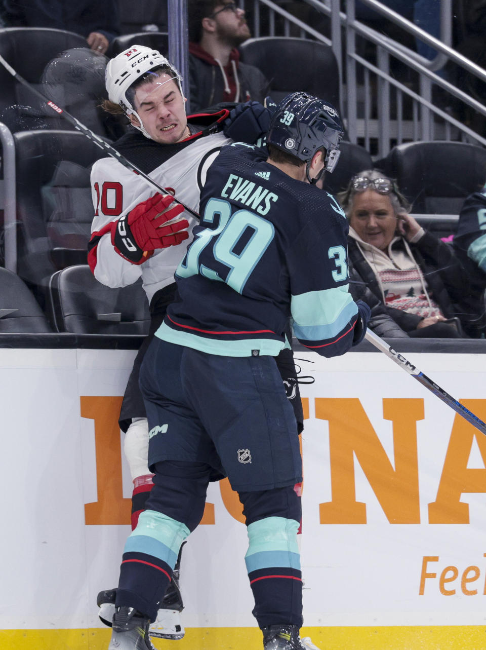 Seattle Kraken defenseman Ryker Evans (39) checks New Jersey Devils right wing Alexander Holtz (10) during the second period of an NHL hockey game Thursday, Dec. 7, 2023, in Seattle. (AP Photo/Jason Redmond)