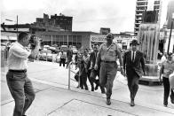 <p>Neshoba County Sheriff Lawrence Rainey, center, arrives at the Federal building between two FBI men as he is brought in to be arraigned before U.S. Commissioner on violating civil rights of three Freedom Summer workers in Meridian, Miss., Oct. 3, 1964. (Photo: Horace Cort/AP) </p>