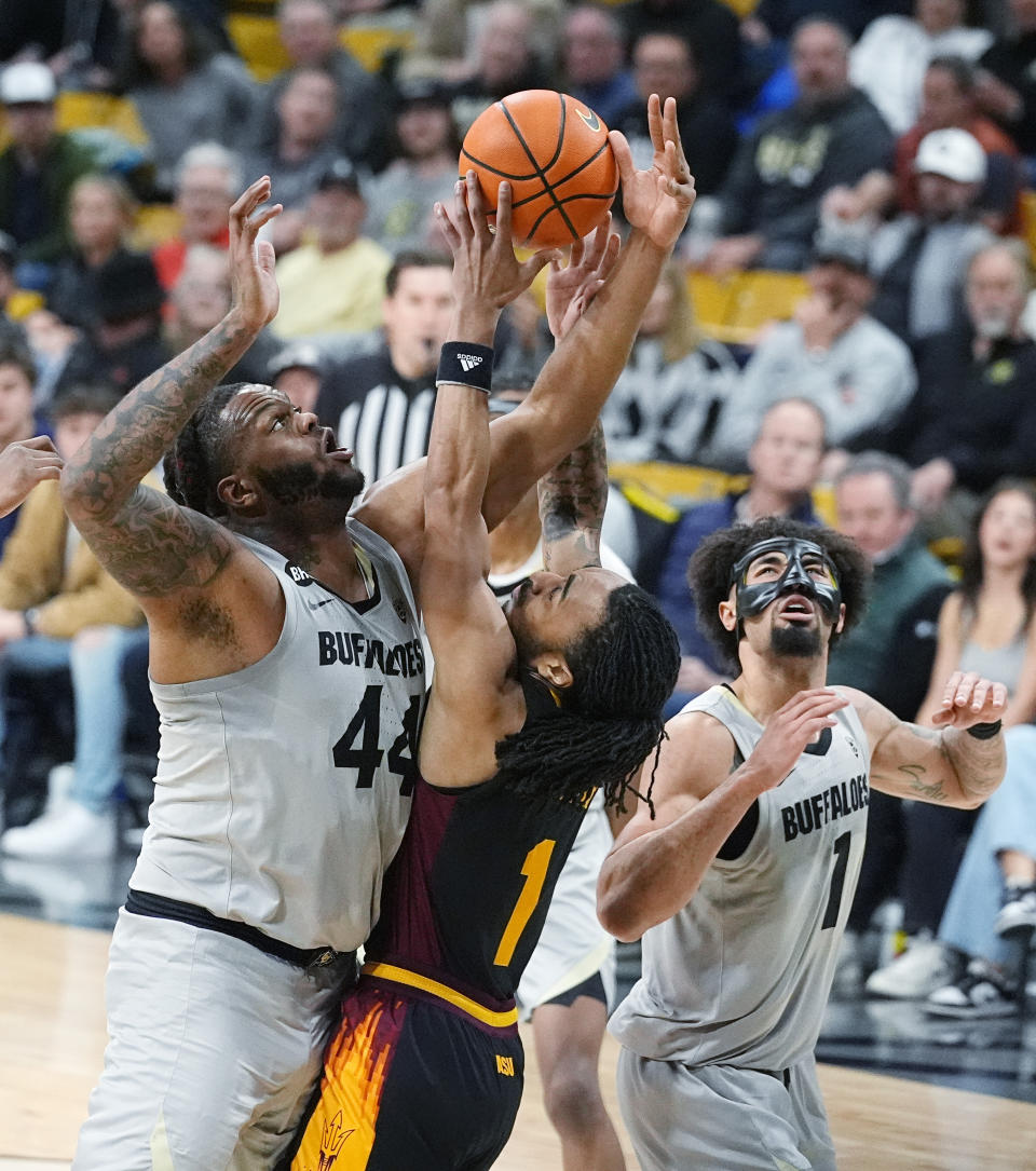 Arizona State guard Frankie Collins, center, fights for control of a rebound with Colorado center Eddie Lampkin Jr., left, and guard J'Vonne Hadley, right, in the second half of an NCAA college basketball game Thursday, Feb. 8, 2024, in Boulder, Colo. (AP Photo/David Zalubowski)