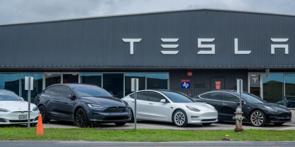 Tesla vehicles sitting on the lot at a Tesla dealership.