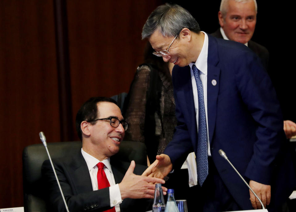 China's Central Bank Governor Yi Gang shakes hands with U.S. Treasury Secretary Steve Mnuchin, left, during the G20 Finance Ministers and Central Bank Governors Meeting Saturday, June 8, 2019, In Fukuoka, Japan. (Kim Kyung-hoon/Pool Photo via AP)