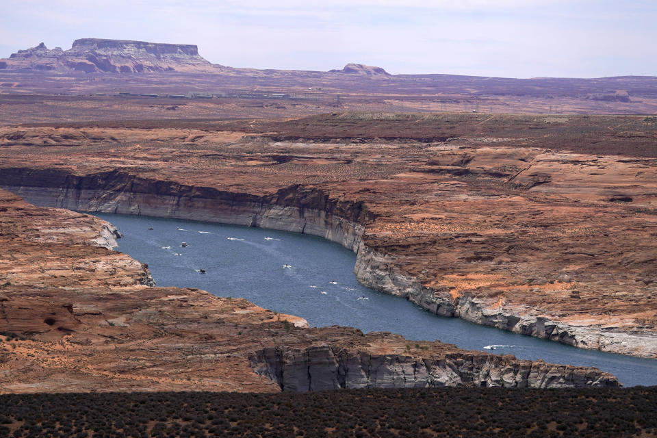 FILE - Boats move along Lake Powell along the Upper Colorado River Basin, June 9, 2021, in Wahweap, Ariz. In Arizona, water officials are concerned, though not panicking, about getting water in the future from the Colorado River as its levels decline and the federal government talks about the need for states in the Colorado River Basin to reduce use. (AP Photo/Ross D. Franklin, File)