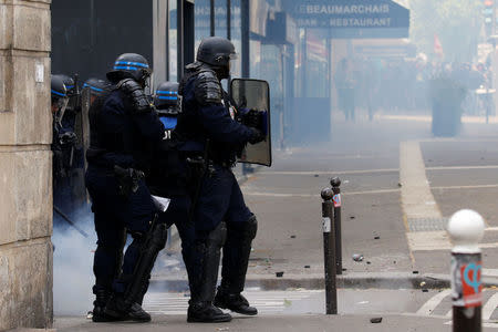 Tear gas floats around French CRS riot police who secure an area during clashes at the traditional May Day labour union march in Paris, France, May 1, 2017. REUTERS/Gonzalo Fuentes