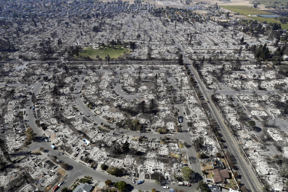 FILE - This Oct. 14, 2017 file photo shows an aerial view shows the devastation of the Coffey Park neighborhood after the Tubbs swept through in Santa Rosa, Calif. Pacific Gas & Electric says its plan for getting out of bankruptcy has won overwhelming support from the victims of deadly Northern California wildfires ignited by the utility's fraying electrical grid. The victims backed PG&E's blueprint despite concerns that they will be shortchanged by a $13.5 billion fund that's supposed to cover their losses. The preliminary results of a vote announced Monday, May 18, 2020, keep PG&E on track for meeting a June 30 deadline to get out of bankruptcy so it can qualify for coverage from a California wildfire insurance fund that was created to help protect the utility from getting into financial trouble again. (AP Photo/Marcio Jose Sanchez, File)