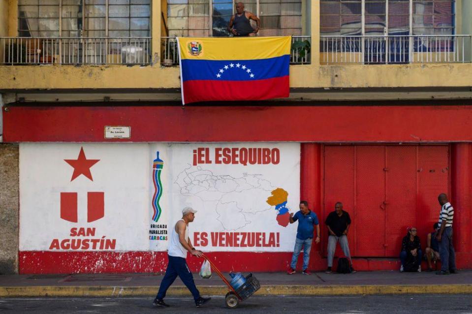 Una calle de Caracas en la que se ve un mural sobre el Esequibo.