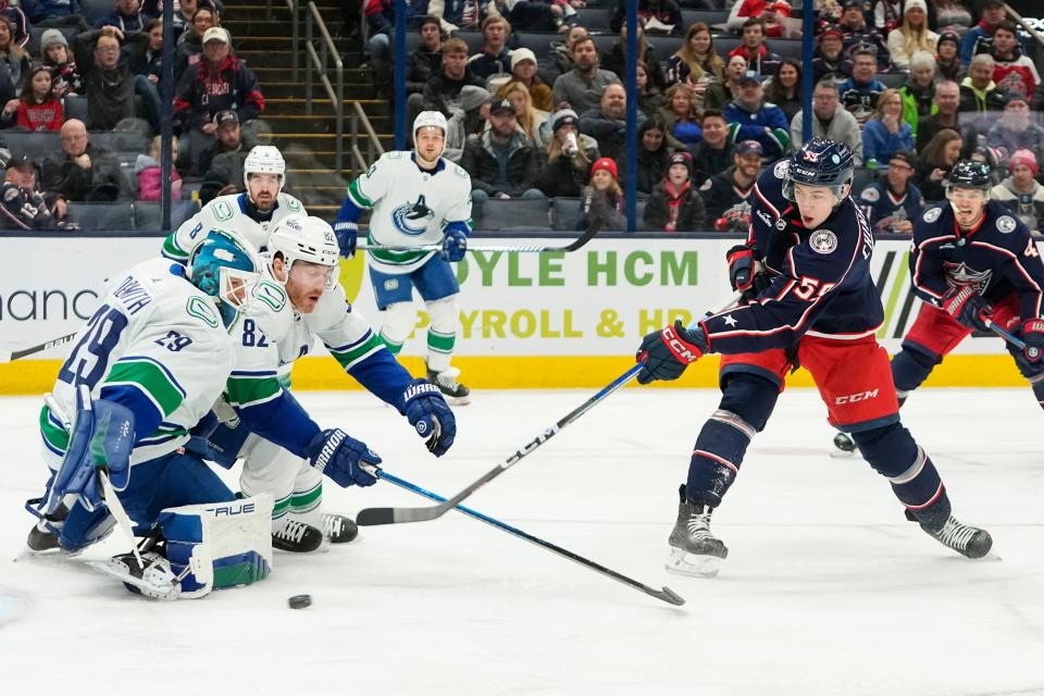 Jan 15, 2024; Columbus, Ohio, USA; Columbus Blue Jackets right wing Yegor Chinakhov (59) scores past Vancouver Canucks goaltender Casey DeSmith (29) and defenseman Ian Cole (82) during the first period of the NHL hockey game at Nationwide Arena.