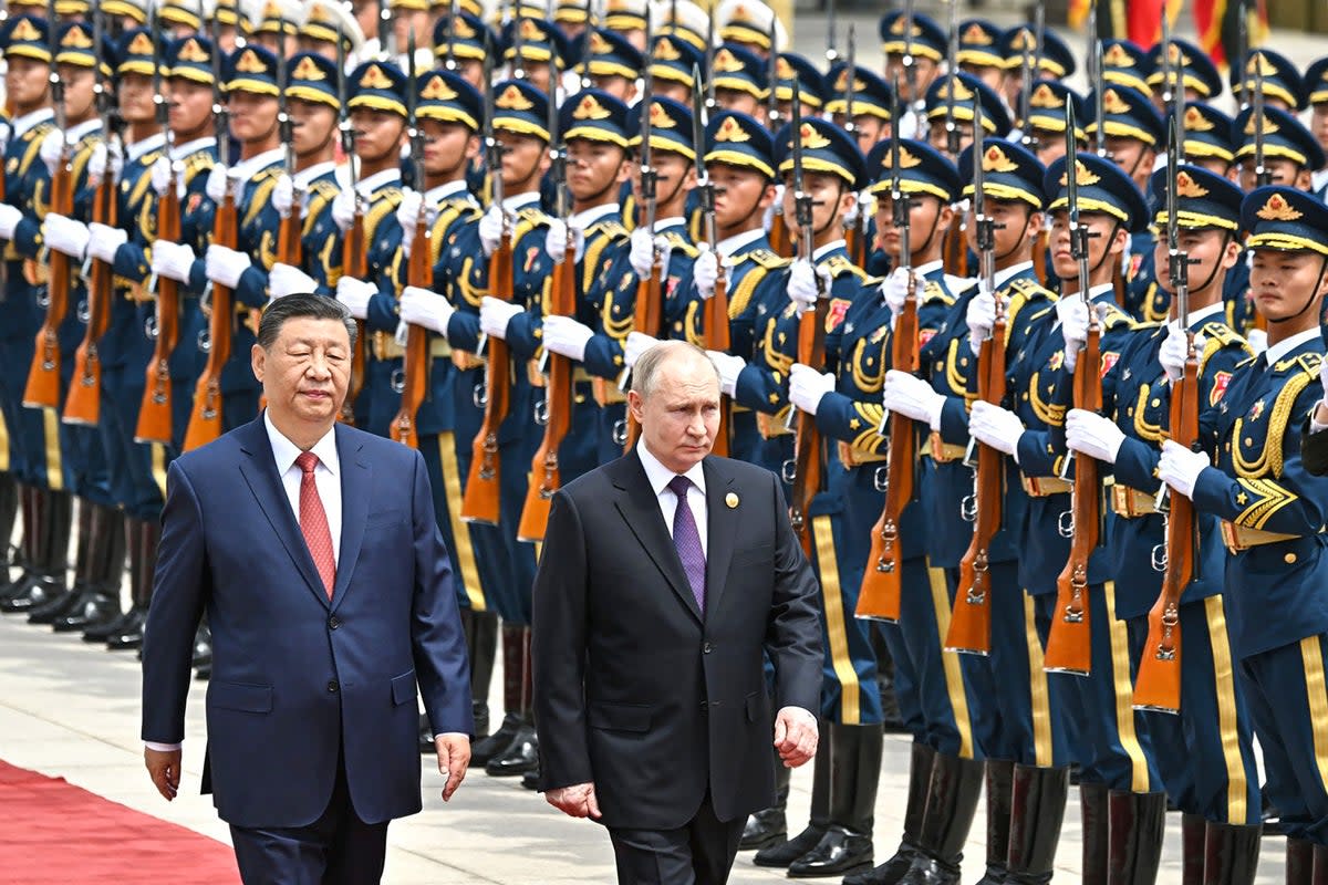 Vladimir Putin (R) and China's President Xi Jinping review a military honour guard  (RUSSIAN PRESIDENTIAL PRESS OFFIC)