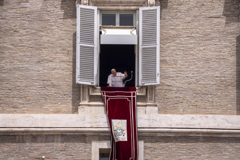 Pope Francis leans from his studiio's window overlooking St. Peter's Square at The Vatican, Sunday, June 9, 2024, where faithful and pilgrims gathered for the traditional Sunday's blessing at the end of the Angelus prayer. (AP Photo/Domenico Stinellis)