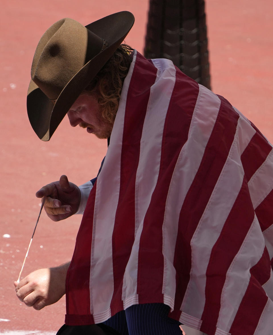 Ryan Crouser, of United States takes off his finger tape after winning the gold in the final of the men's shot put at the 2020 Summer Olympics, Thursday, Aug. 5, 2021, in Tokyo, Japan. (AP Photo/Charlie Riedel)