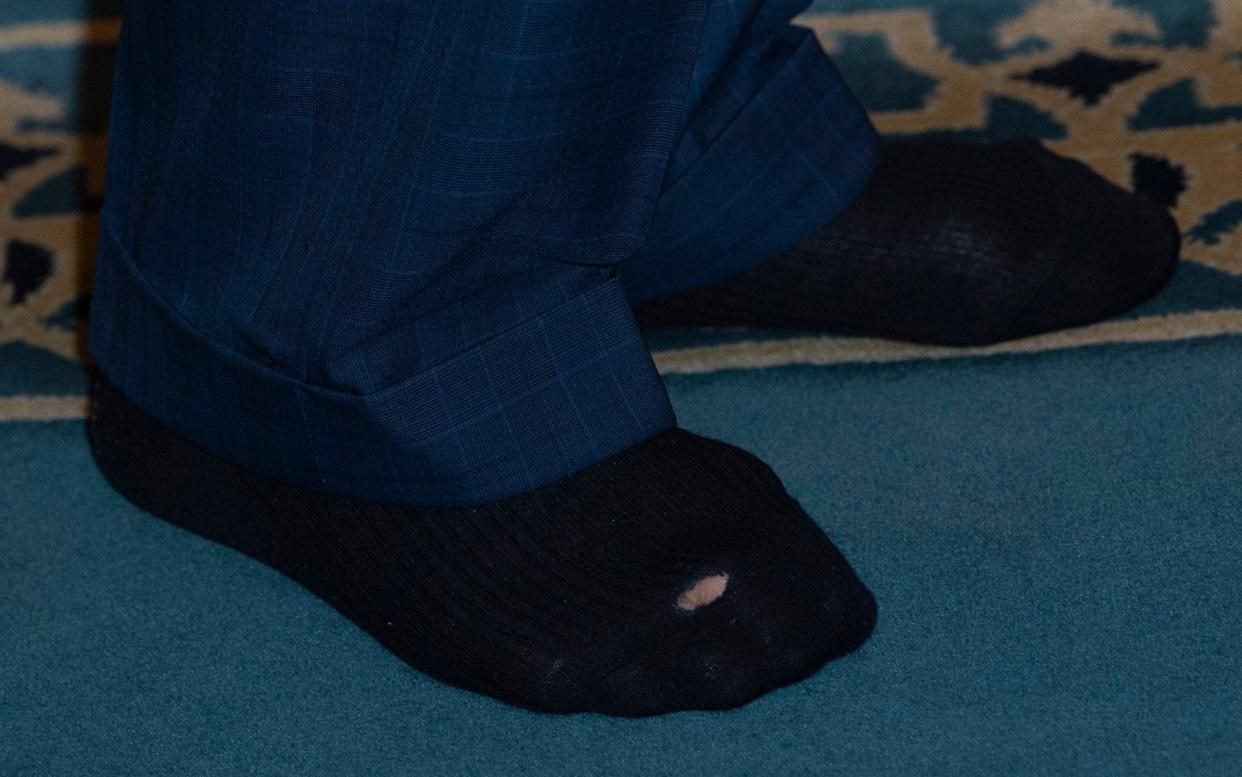 The hole in the black sock was visible as the King took off his shoes inside the mosque - Eddie Mulholland