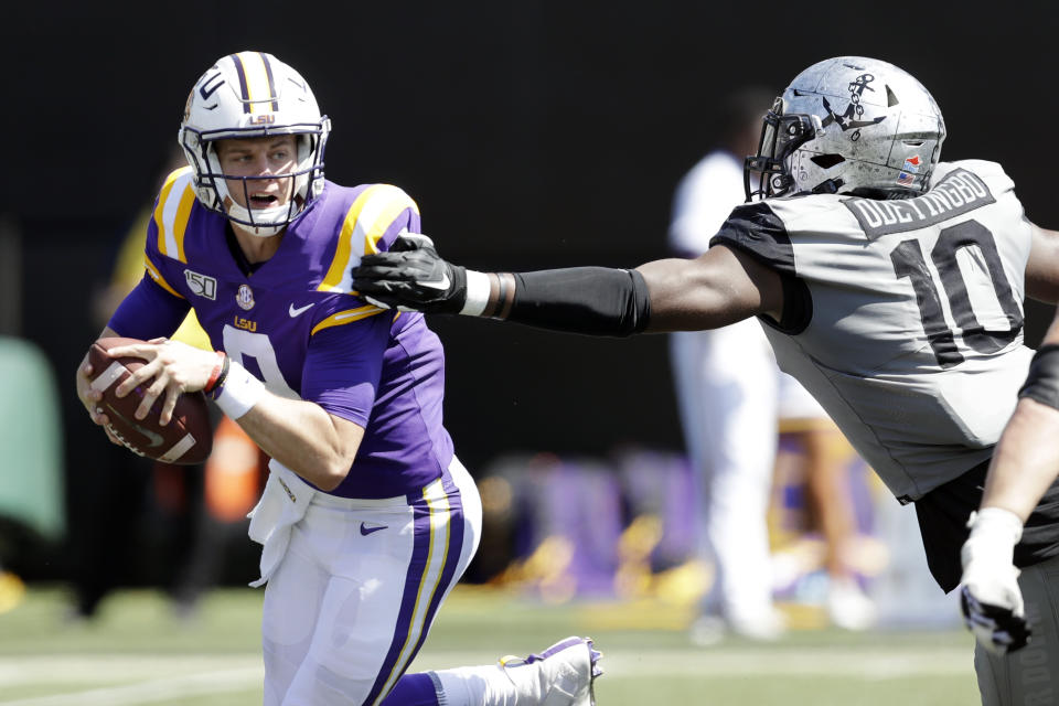 LSU quarterback Joe Burrow, left, scrambles away from Vanderbilt defensive lineman Dayo Odeyingbo (10) in the first half of an NCAA college football game Saturday, Sept. 21, 2019, in Nashville, Tenn. (AP Photo/Mark Humphrey)