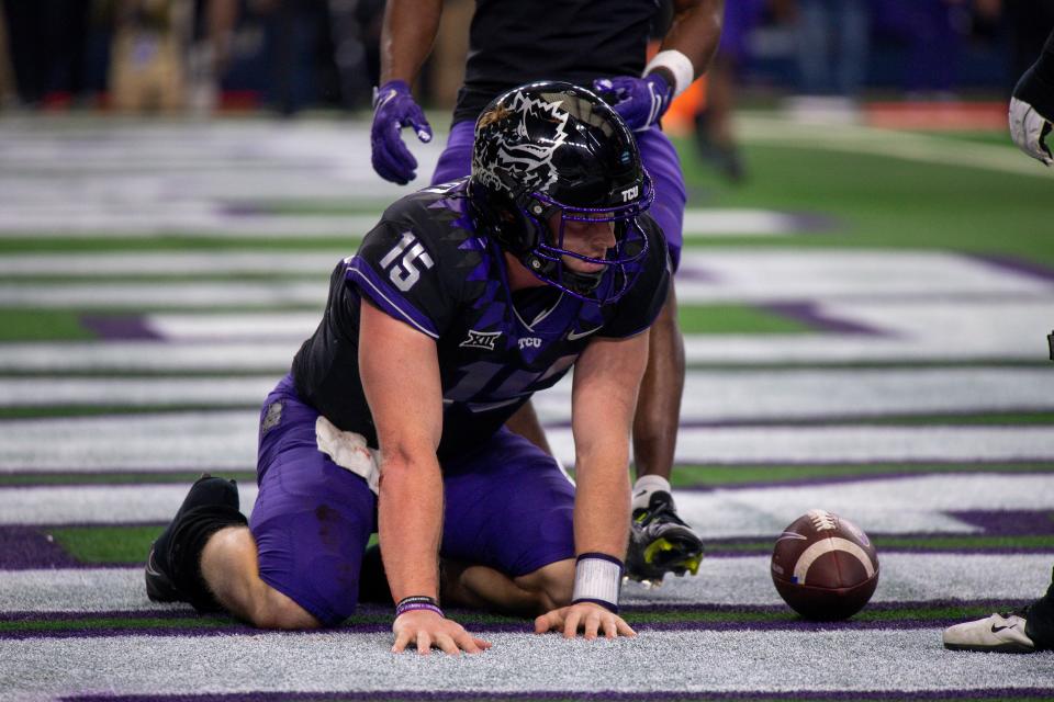 TCU quarterback Max Duggan (15) kneels on the field after scoring a touchdown against Kansas State during the second half of the 2022 Big 12 title game at AT&T Stadium.