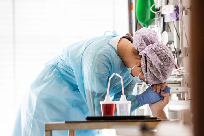 A nurse tightly holds the hand of a patient with COVID-19 shortly after the completion of an operating procedure at Herlev Hospital in Copenhagen, Denmark, in this undated photo taken in May 2020.  (Ritzau Scanpix/Olafur Steinar Rye Gestsson via Reuters)