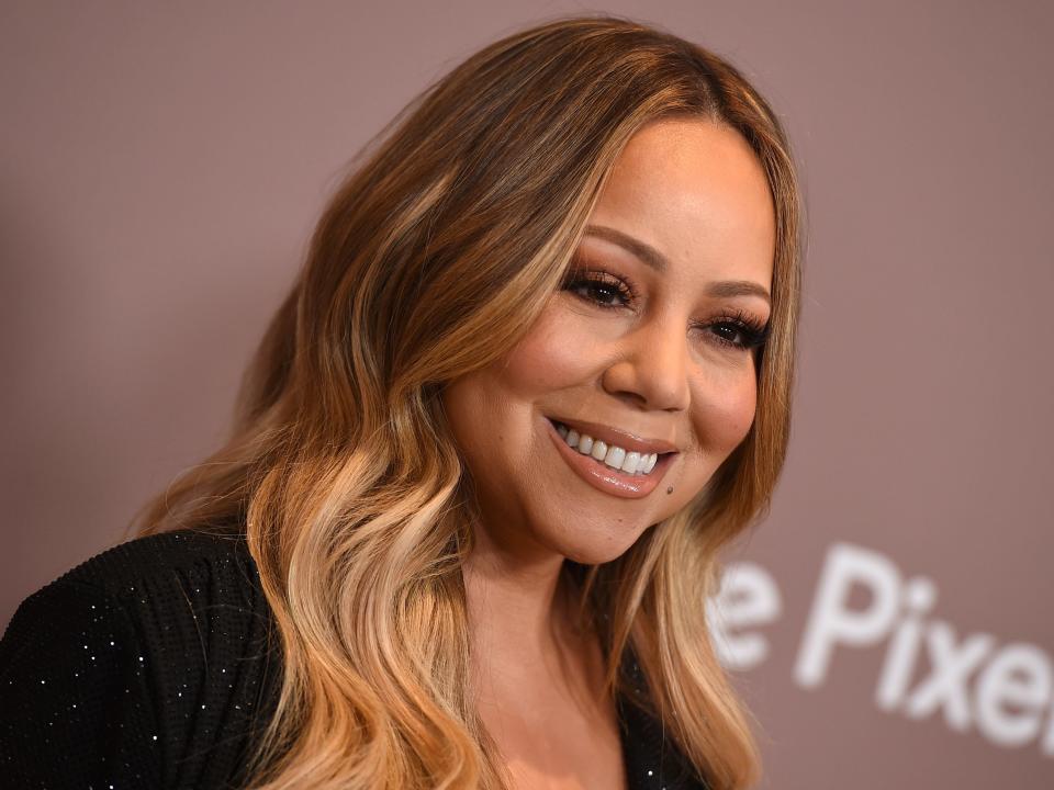 Mariah Carey smiles on the red carpet,