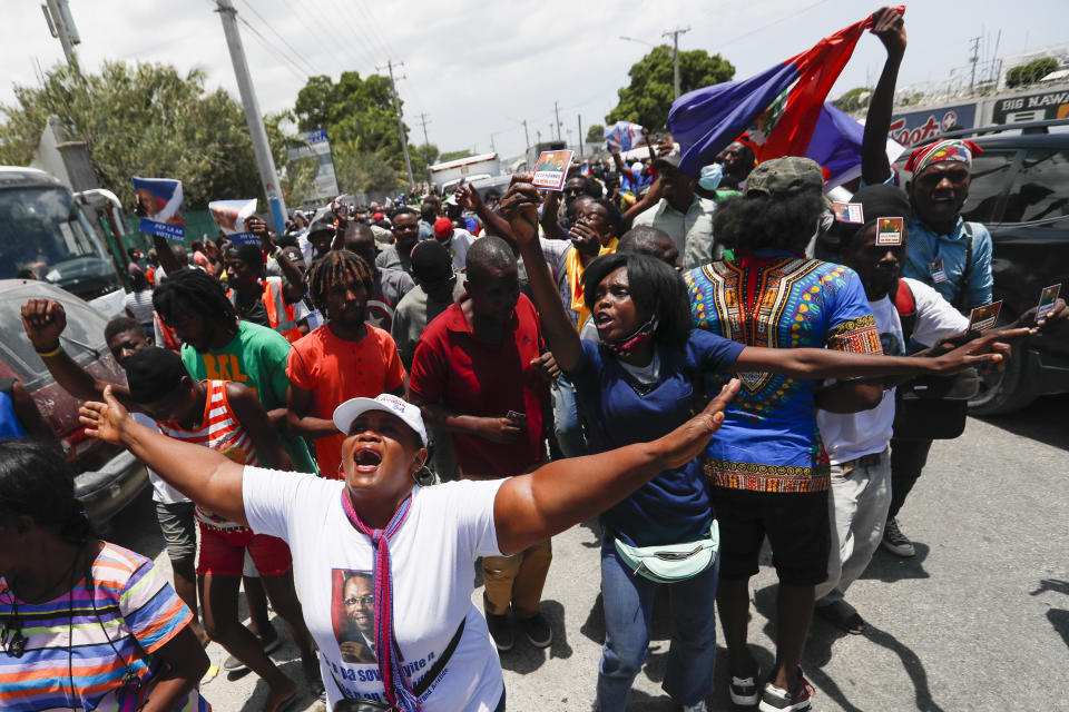 Supporters of former Haitian President Jean-Bertrand Aristide celebrate his arrival from Cuba, where he underwent medical treatment, in Port-au-Prince, Haiti, Friday, July 16, 2021. President Jovenel Moise was assassinated at his residency on July 7. (AP Photo/Fernando Llano)