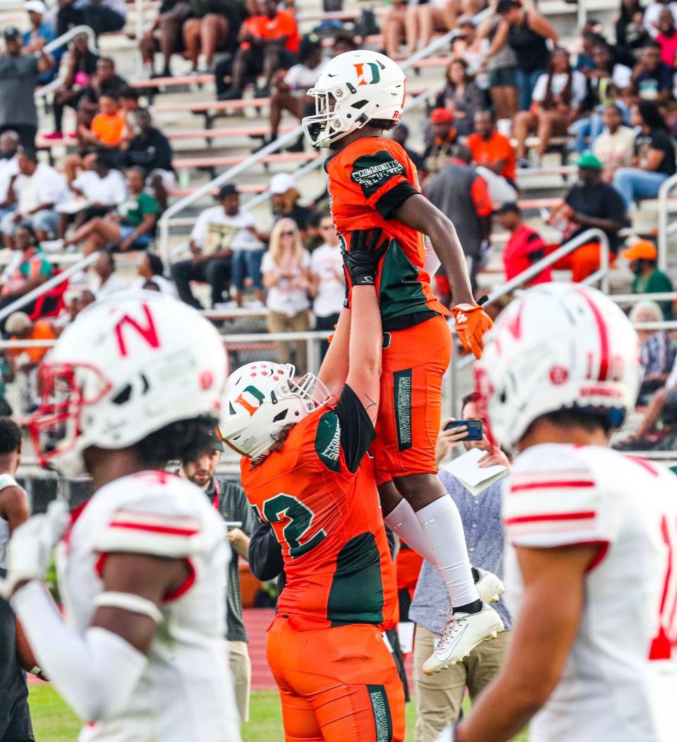 Shawn Russ celebrates with his Dunbar teammate, Nick Giordano after he scored on a big reception in the end zone. Action in the North Fort Myers at Dunbar football game Friday night, September 2, 2022. 