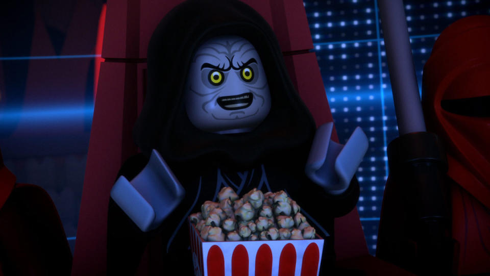 A LEGO Palpatine sits in his throne happy eating popcorn