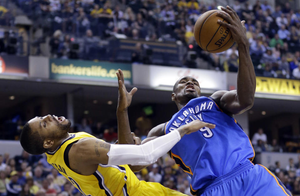 Oklahoma City Thunder forward Serge Ibaka, right, fouls Indiana Pacers guard C.J. Watson as he grabs a rebound in the second half of an NBA basketball game in Indianapolis, Sunday, April 13, 2014. Ibaka was also charged with a technical after complaining about the foul call. The Pacers defeated the Thunder 102-97. (AP Photo/Michael Conroy)