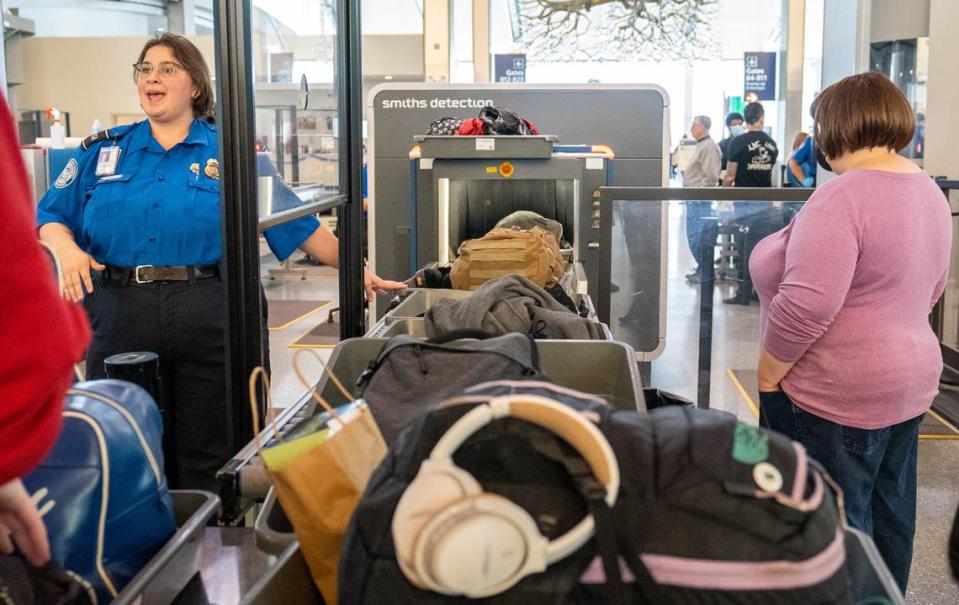 A Sacramento International Airport Terminal B TSA officer directs passengers through security on Dec. 20, 2022.