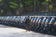 A man walks past parked auto rickshaws during a one-day Janata (civil) curfew imposed as a preventive measure against the COVID-19 coronavirus, in Mumbai on March 22, 2020. - Nearly one billion people around the world were confined to their homes, as the coronavirus death toll crossed 13,000 and factories were shut in worst-hit Italy after another single-day fatalities record. (Photo by INDRANIL MUKHERJEE / AFP) (Photo by INDRANIL MUKHERJEE/AFP via Getty Images)