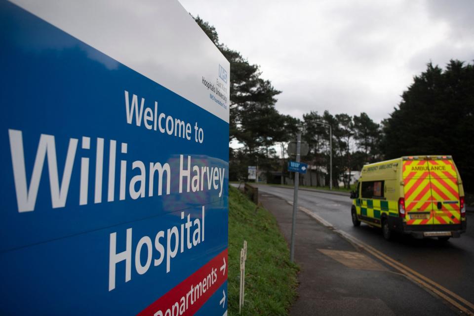 An ambulance passes a sign welcoming people to The William Harvey Hospital, where a temporary field hospital, a Nightingale 'surge hub', is being constructed, in Ashford, in south-east England on January 2, 2022, as fuelled by the highly contagious Omicron variant, daily cases of Covid-19 have ballooned. - England is building temporary hospitals to help cope with rising coronavirus cases. The new "surge hubs" will deal with a potential overspill of inpatients as surging virus cases put the country's health service on a "war footing", according to officials.