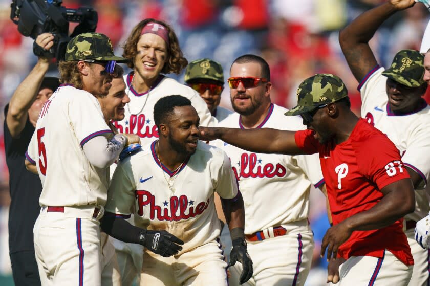 Philadelphia Phillies' Roman Quinn, second from front left, celebrates with teammates.