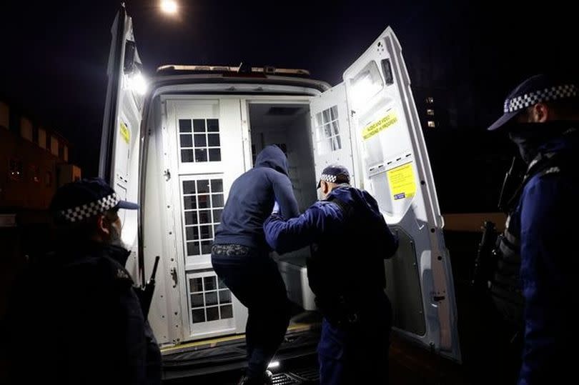 Police officers detain a person. File image