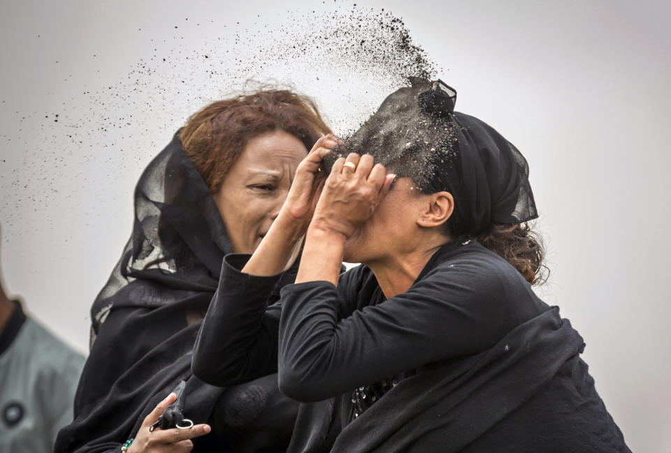 An Ethiopian relative of a crash victim throws dirt in her own face after realising that there is nothing physical left of her loved one, as she mourns at the scene where the Ethiopian Airlines Boeing 737 Max 8 crashed shortly after takeoff on Sunday killing all 157 on board, near Bishoftu, south-east of Addis Ababa, in Ethiopia Thursday, March 14, 2019. About 200 family members of people who died on the crashed jet stormed out of a briefing with Ethiopian Airlines officials in Addis Ababa on Thursday, complaining that the airline has not given them adequate information. (AP Photo/Mulugeta Ayene)