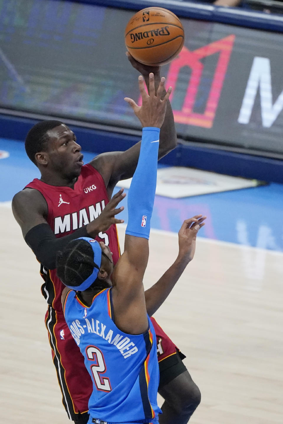 Miami Heat guard Kendrick Nunn, rear, shoots in front of Oklahoma City Thunder guard Shai Gilgeous-Alexander (2) in the second half of an NBA basketball game Monday, Feb. 22, 2021, in Oklahoma City. (AP Photo/Sue Ogrocki)