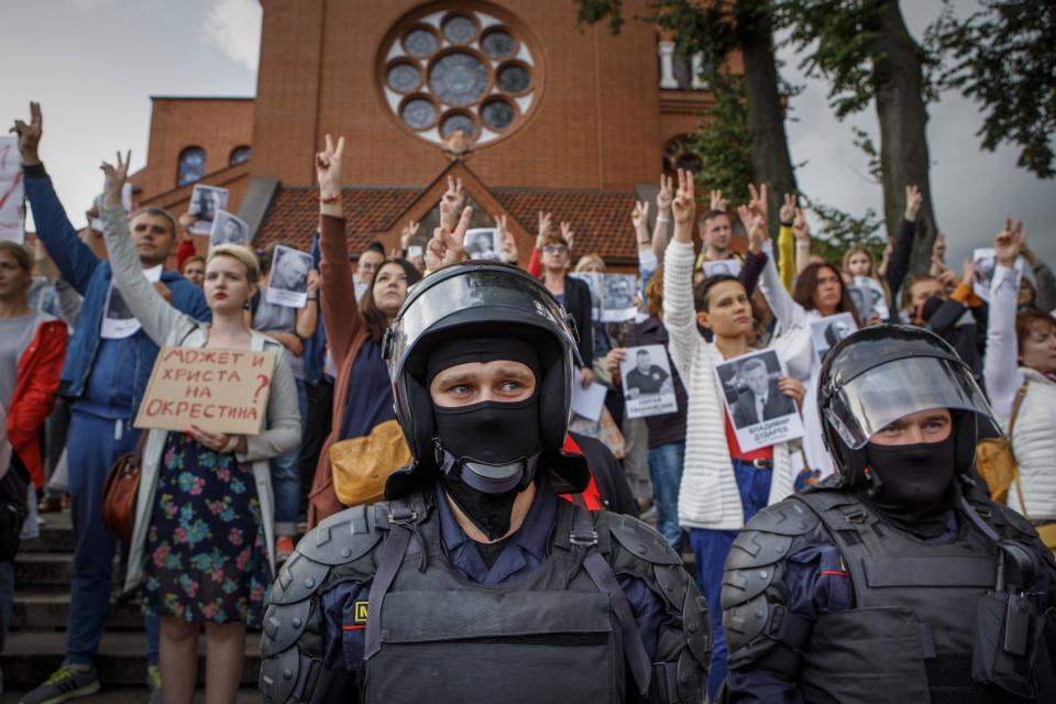 FILE - Riot police block protesters in front of the Sts. Simon and Helena Catholic Church in Minsk, Belarus, Thursday, Aug. 27, 2020. In a famous incident amid anti-government protests, about 100 people took refuge from police inside the landmark known as the “Red Church” because of the color of its bricks. (AP Photo, File)