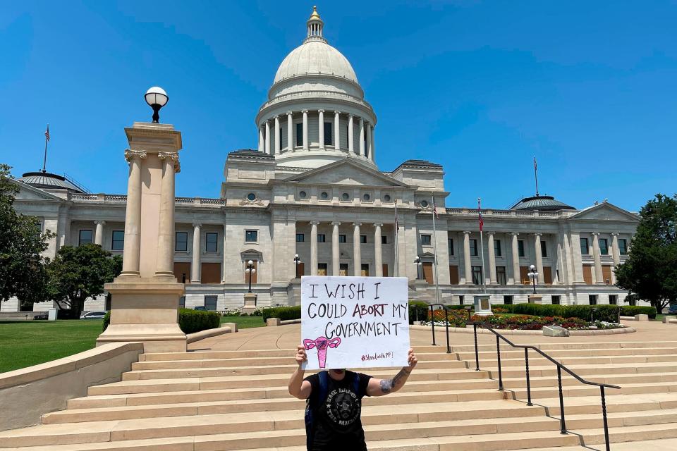 FILE - A demonstrator holds a sign outside the Arkansas Capitol in Little Rock, Ark., June 24, 2022, protesting the U.S. Supreme Court's decision overturning Roe v. Wade.