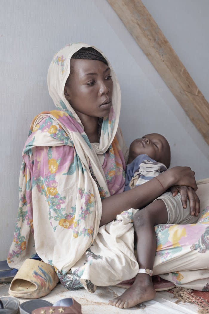 Afrah Amdelkarim Hamid, 24, and her child, 2-year-old Mandoub, wait to see medical personnel at hospital run by Doctors Without Borders in Aboutengue, a refugee site in eastern Chad a few hours from Adré. Aboutengue is home to some 50,000 refugees fleeing ongoing hostilities in Sudan.<span class="copyright">Nicolò Filippo Rosso</span>