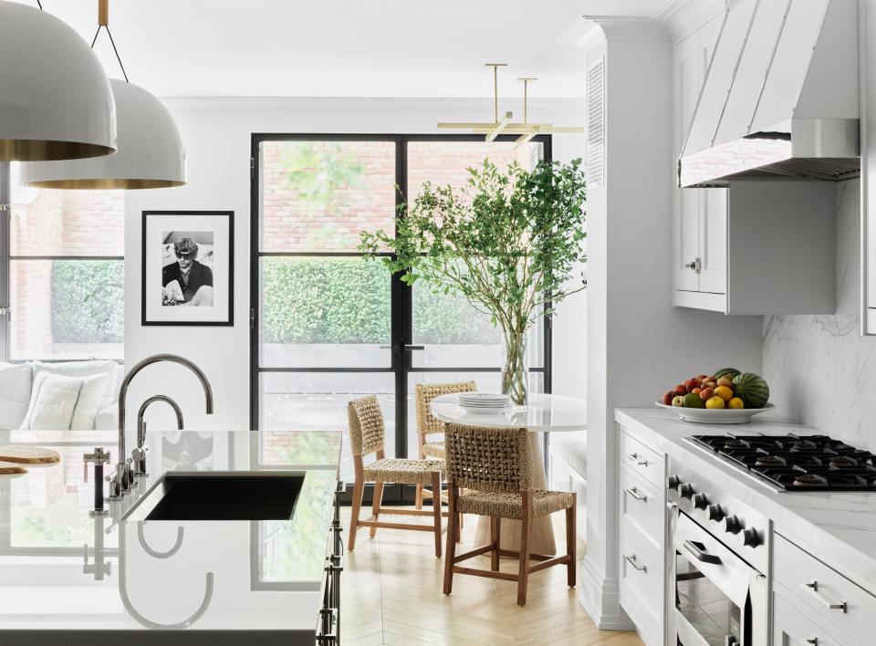 In the kitchen, painted Benjamin Moore Decorator’s White, the appliances are by Gaggenau, sink by 
Dornbracht, and chairs from Mecox.
