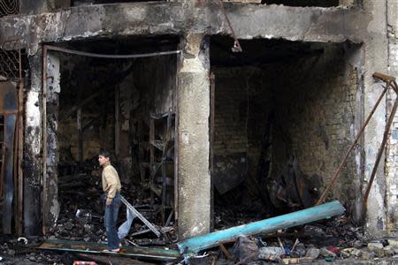 A boy stands at the site of car bomb attack in Baghdad's Karrada district February 18, 2014. REUTERS/Ahmed Saad