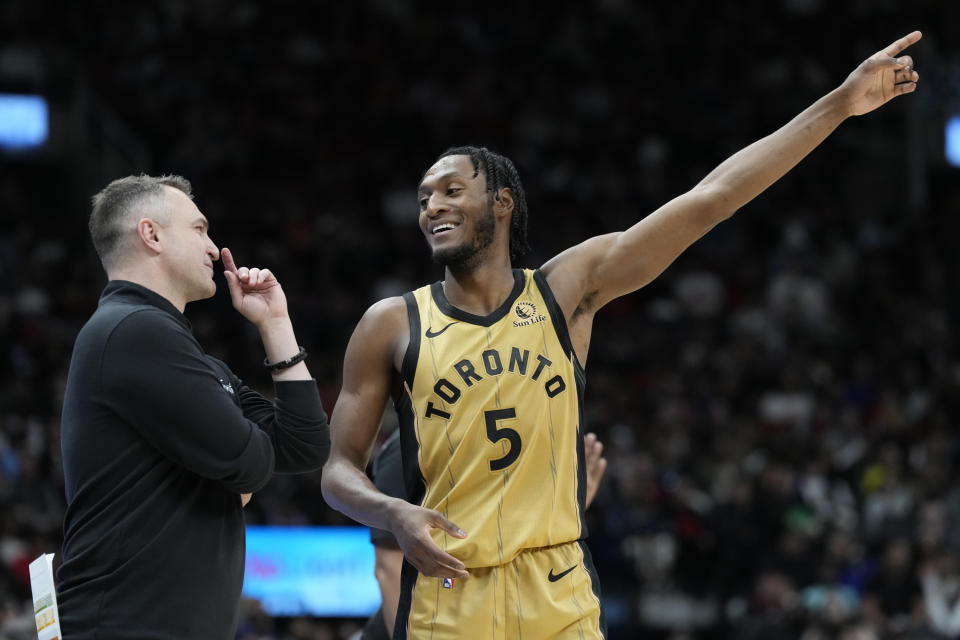 Toronto Raptors guard Immanuel Quickley (5) speaks with his head coach Darko Rajakovic, left, during second-half NBA basketball game action in Toronto, Sunday, April 7, 2024. (Frank Gunn/The Canadian Press via AP)