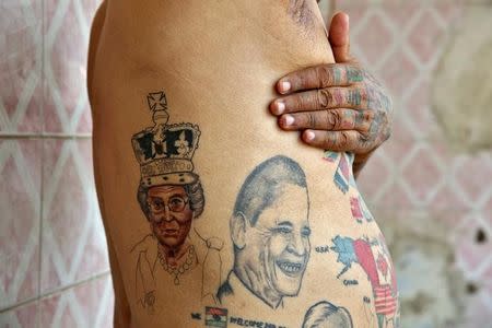 Guinness Rishi, 74, multiple world record holder including most flags tattooed on his body, poses for a photograph outside his apartment in New Delhi, India May 20, 2016. REUTERS/Cathal McNaughton