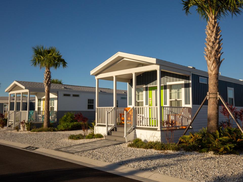 Two cabana cabins with palm trees.